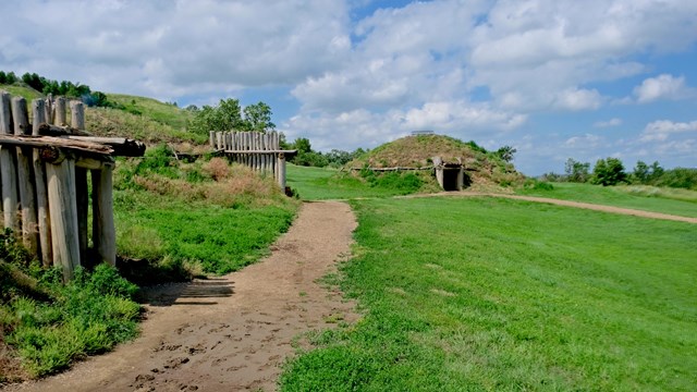 earth lodge village in a green prairie 